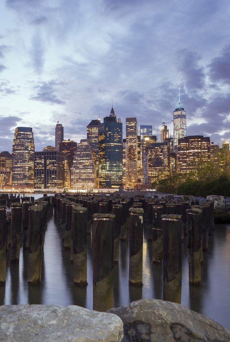 Lower Manhattan skyline across the East River from Brooklyn Bridge Park at dusk