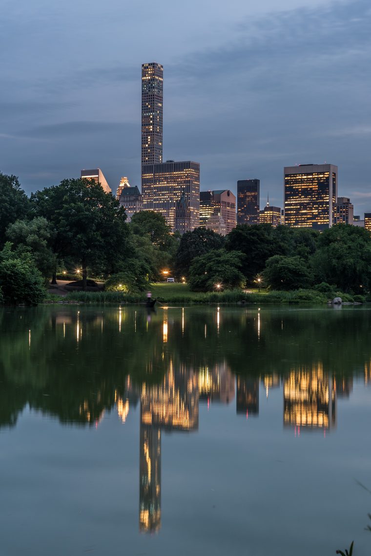 Still lake reflecting the skyline in Central Park at blue hour
