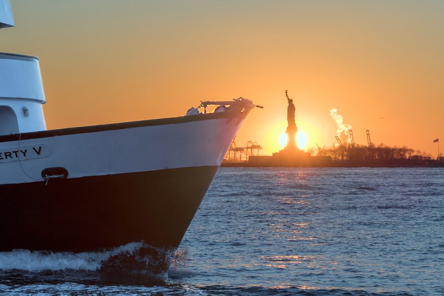 The Statue of Liberty at sunset seen from the deck of a New York ferry