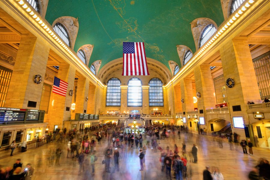 The Main Concourse of Grand Central Terminal with American flags and sunbeams